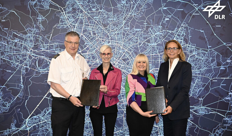 Personen zeigen Mappen mit Kooperationsrahmenvereinbarung