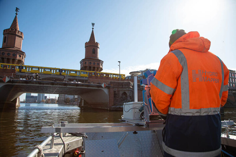 Mann mit Vermessungsgerät auf einem Boot
