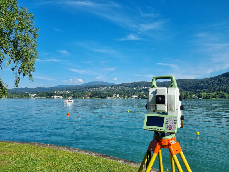 Eine Totalstation steht am Ufer des Wörthersees