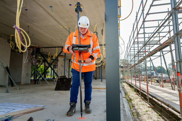 Mann bedient auf Baustelle ein Positionierungssystem