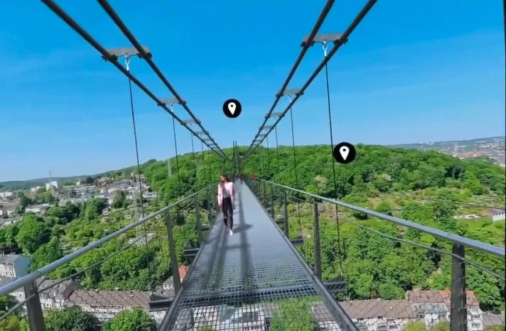 Frau geht über Hängebrücke